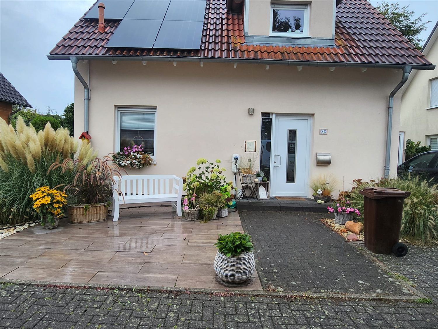 Gepflegter Hauseingang mit Vorgarten, Bepflanzung und sauberem Pflaster